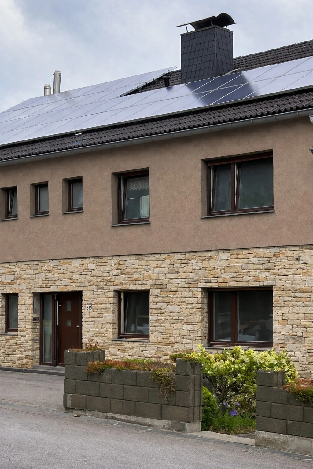 Individueller Entwurf: dasselbe Wohnhaus mit braunem Putz im Obergeschoss und Bruchsteinverblender im Erdgeschoss