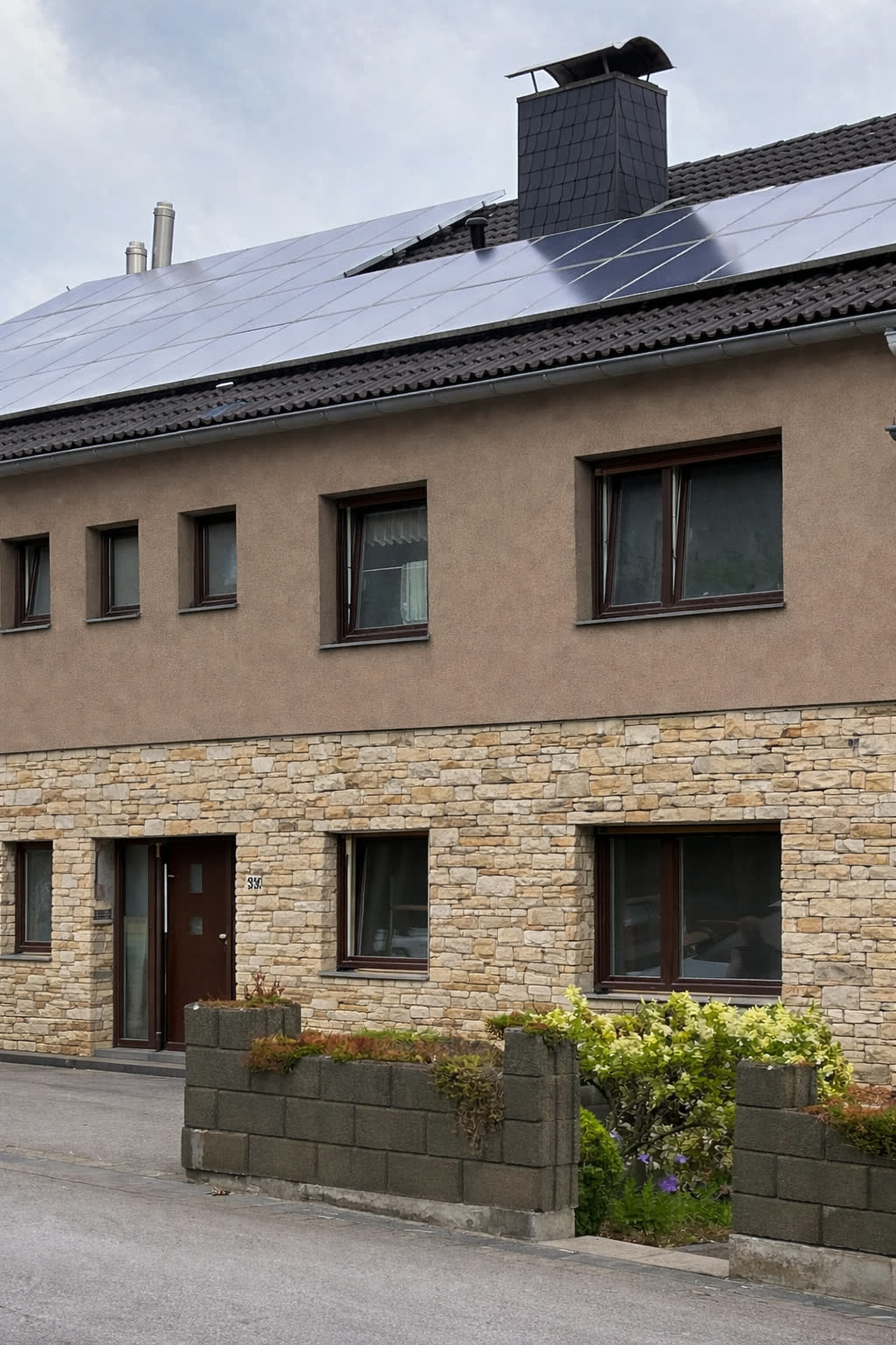 KI-Entwurf: dasselbe Haus mit Putzfassade im Obergeschoss und Natursteinverblendung im Erdgeschoss